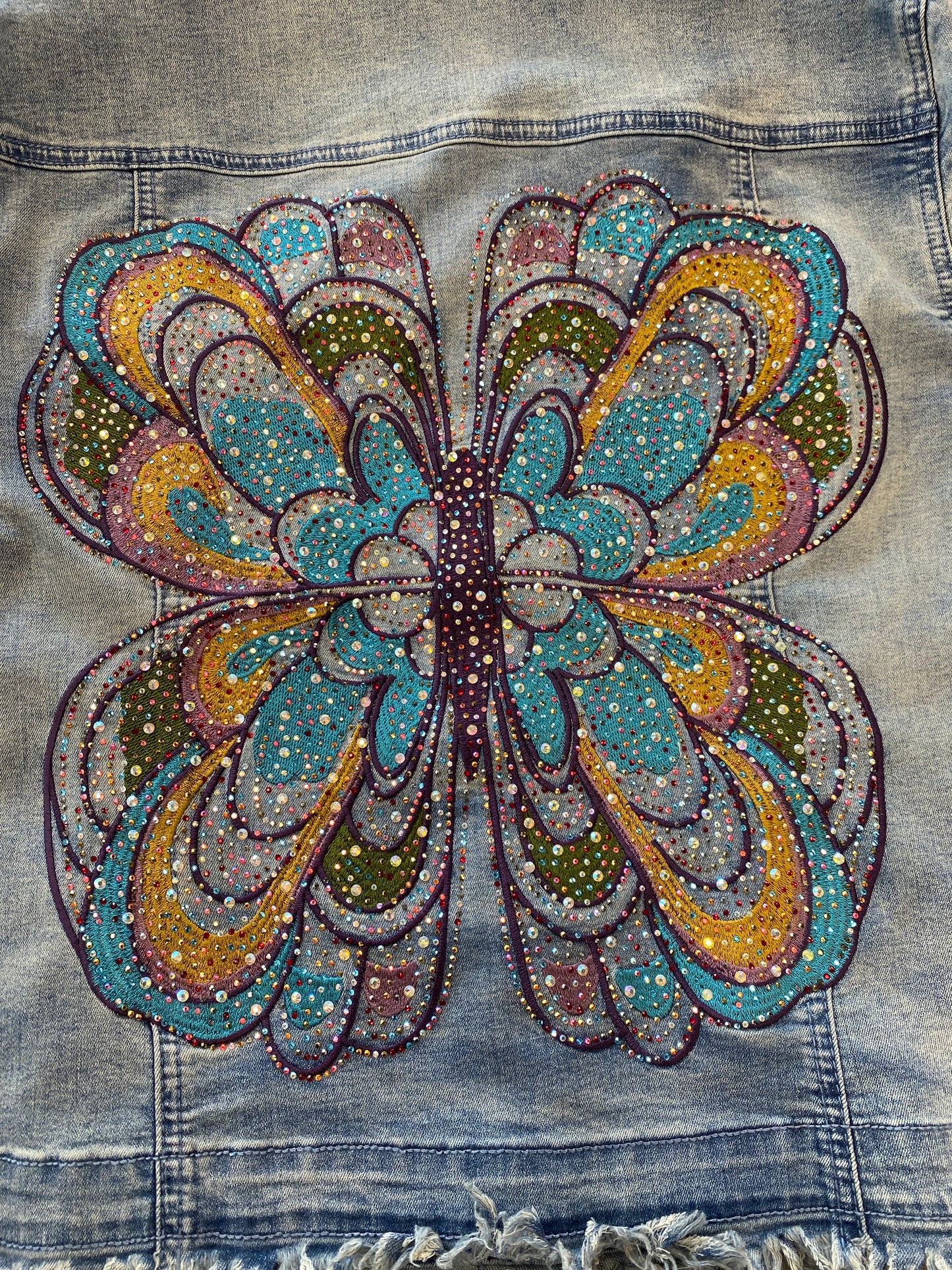 Denim jacket with a colorful butterfly design made of beads