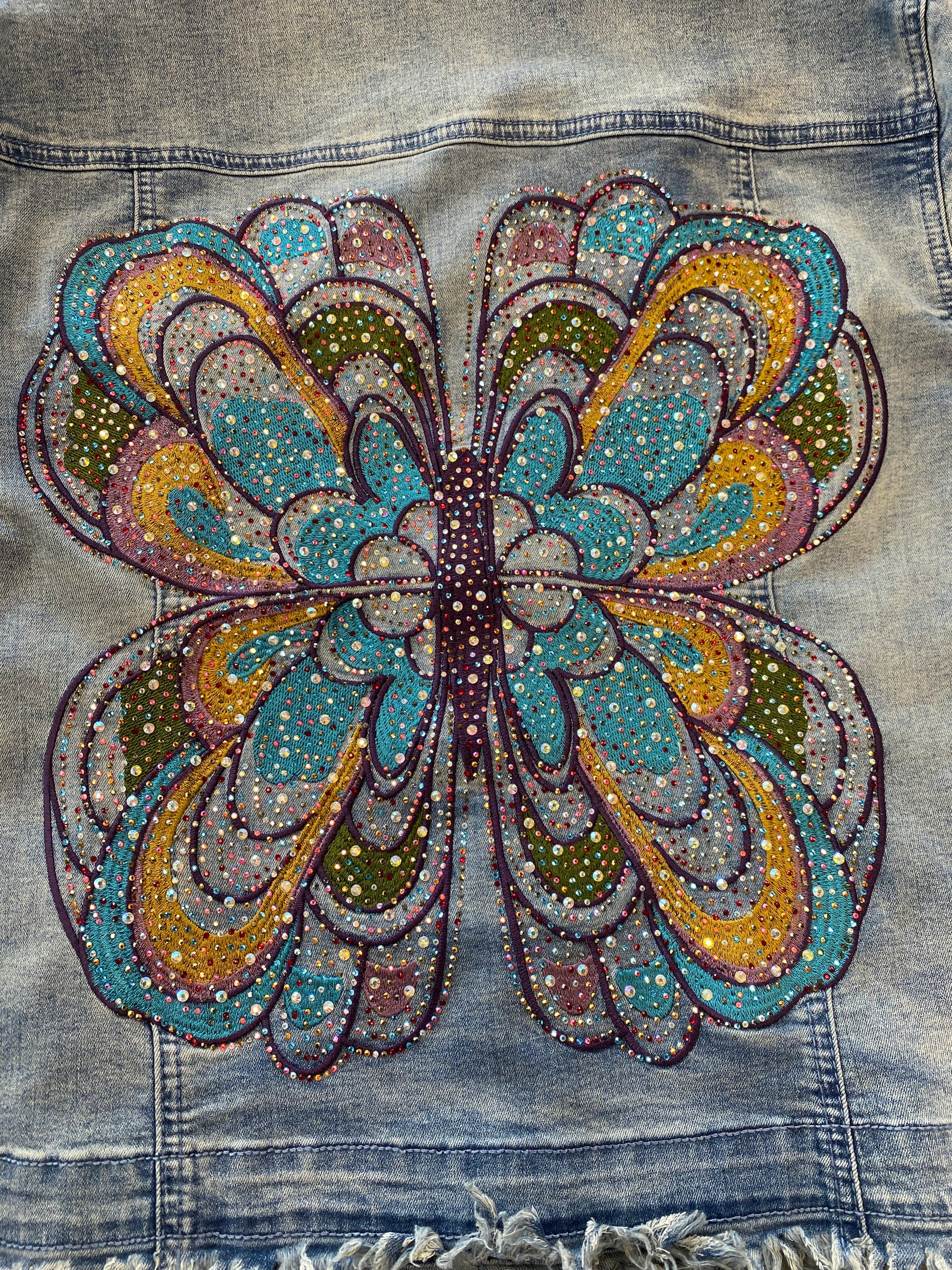 Denim jacket with a colorful butterfly design made of beads