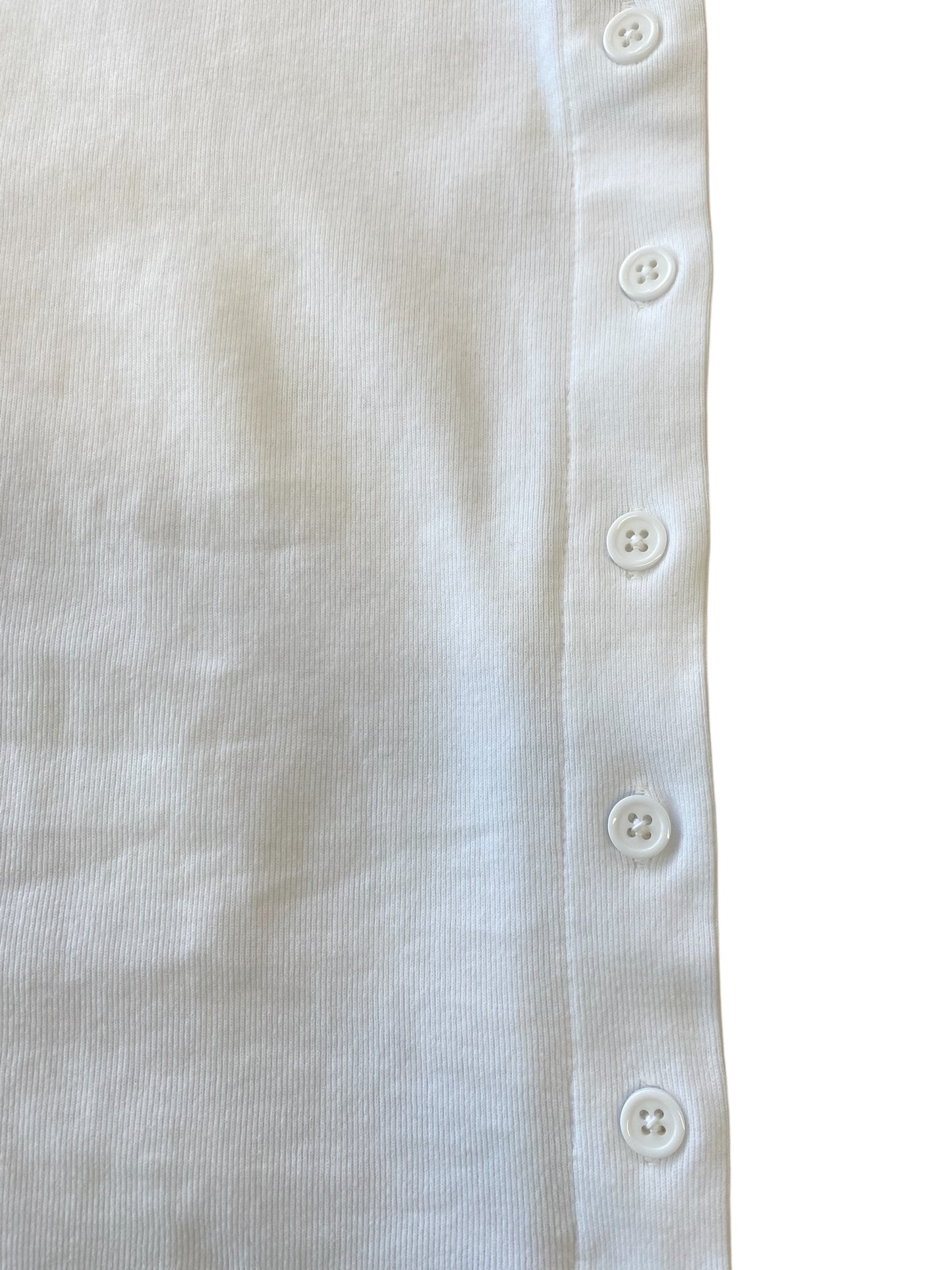 Close-up of a white fabric with button details on a plain background